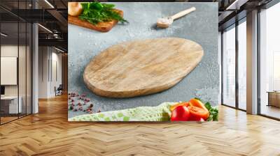 Food mockup. Empty wooden board on concrete table with cooking  ingredients. Wooden board  with spices, greens and tomatoes for menu. Food menu mockup. Cooking composition with empty place. Wall mural