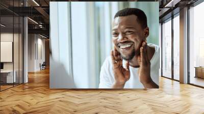 Beauty, face and skincare with a black man looking in the bathroom mirror during his morning routine at home. Skin, head and reflection with a handsome male grooming for wellness or natural care Wall mural