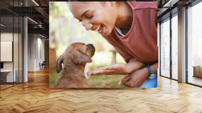 Black woman, puppy and happy with smile, playful and being loving outdoor on grass. Love, African American female and girl with small pet, dog and canine for bonding, happiness and have fun outside. Wall mural