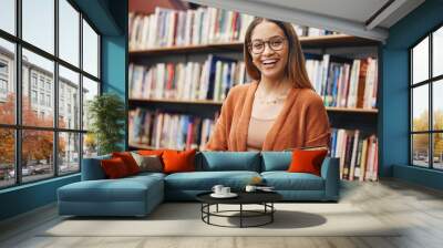 Face, student and woman in university in library ready for learning. Portrait, education and happy female from Brazil standing by bookshelf with book for studying, knowledge and literature research. Wall mural