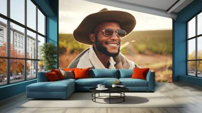 Farm, agriculture and sustainability with a black man farmer outdoor on a grass field or land for organic farming. Agricultural, sustainable and green with a male wearing a hat and sunglasses outside Wall mural