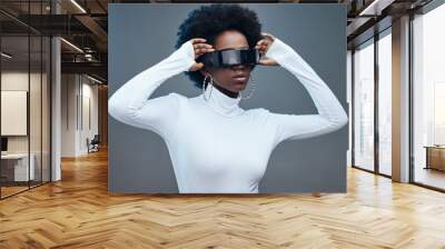 Fashion, hands and black woman with futuristic sunglasses, gen z and stylish with trendy designer brand against studio background. Young, cyberpunk and natural curly hair with beauty and edgy style Wall mural