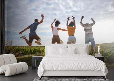 Friends, nature and jumping for freedom in the countryside for summer vacation together in the outdoors. Group of free people enjoying holiday break or travel in joyful fun outside in South Africa Wall mural