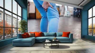 Leg pain, injury and accident at a gym after exercise, training or sport workout with bruise. Fitness, sports and woman athlete limping from a swollen, inflammation or sprain muscle at a studio. Wall mural