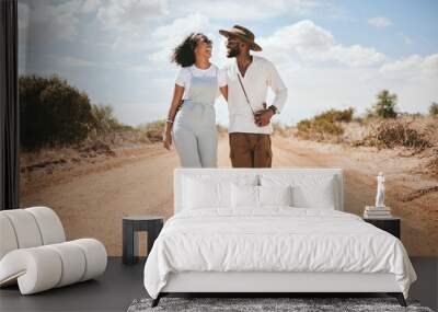 Love, couple and summer with a black woman and man walking on a sand road in the dessert while on vacation. Romance, dating and holiday with a young male and female on a walk together in nature Wall mural