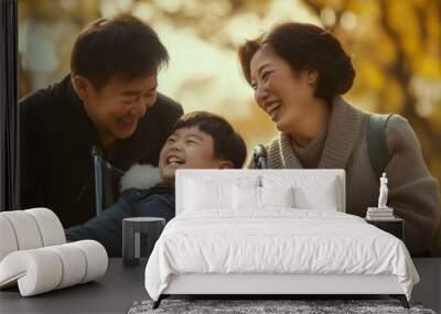 Asian father and mother take care of disabled son in wheelchair in park. Wall mural