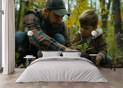 Caucasian father and son planting trees in the forest. Wall mural