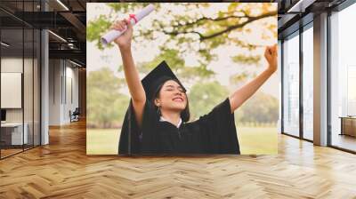 Graduation Concept. Graduated students on graduation day. Asian students are smiling happily on the graduation day. Students wear graduation gowns in the garden Wall mural