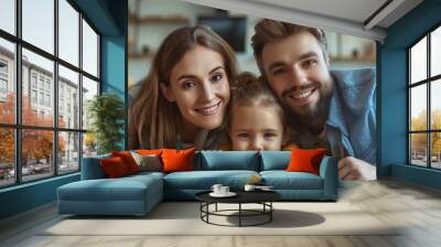 Parents and daughter playing with a wooden house model in the room. Wall mural