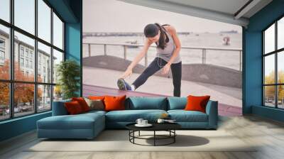 Sports concept. Beautiful girl is exercising on the beach with warm up. Beautiful girl is happy to exercise. Wall mural