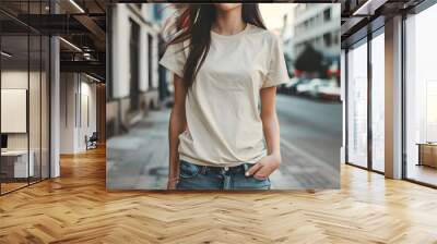 Young model girl shirt mockup, wearing cream color t-shirt, in the middle of the street at daylight Wall mural