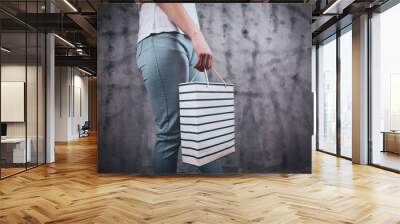 young woman stands with gift bag Wall mural