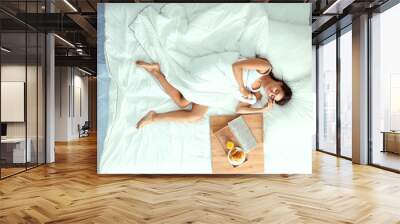 Young beautiful woman lying in bed Wall mural