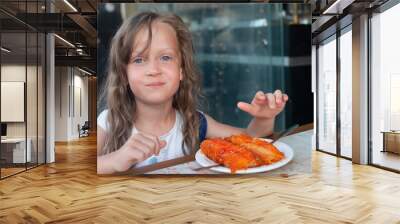 Five years old girl with blue eyes eating middle east dessert kanafeh Wall mural