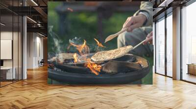 farmer bakes bread outdoors, cooking on open fire Wall mural