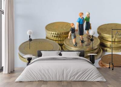 Miniature people, mom son and grandmother on top of a stack of coins Wall mural