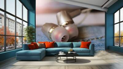 Silver headphones on jeans so close Wall mural