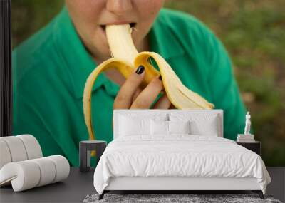 a young woman eats a banana Wall mural