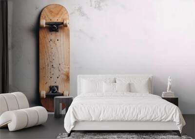 A wooden skateboard with white wheels, lying on a white background, facing the camera. The background has a textured look, like concrete, with small black flecks and lines. Wall mural