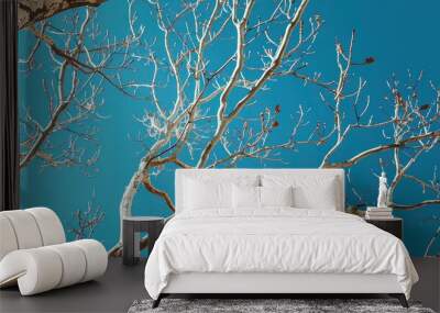 Bare tree branches with a blue sky background. Wall mural