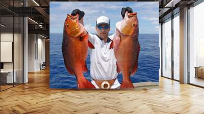 deep sea fishing, man holding two red snapper. Boat fishing, big game Wall mural