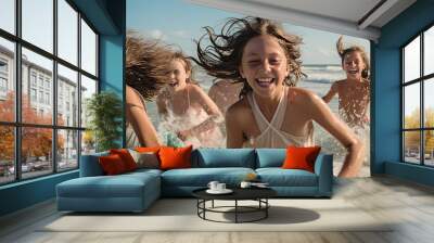 Happy young girls running through the sunny beach Wall mural