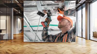 Plasterboard worker making a plasterboard ceiling. Assembling the support structure from CD profiles for plasterboard. Wall mural