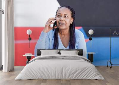 Elderly african woman talking on a call using mobile phone Wall mural