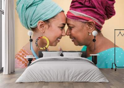 Happy african mother and daughter with forehead together and smiling - African people wearing traditional dress and turban Wall mural