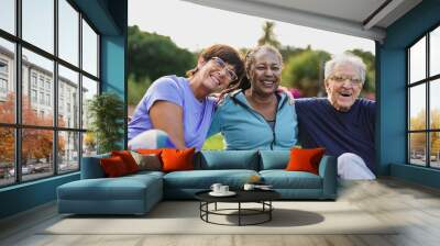 Happy elderly people having fun hugging each other outdoor after yoga lesson Wall mural