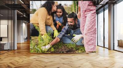 Happy indian family having fun picking up fresh organic carrots from ecologic garden - Parents and children gardening together
 Wall mural