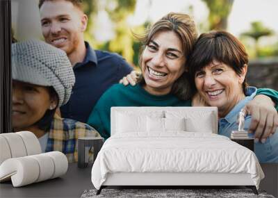 Multigenerational people having fun together outdoor - Multiracial friendship and community concept - Senior women hugging each other while smiling on camera Wall mural