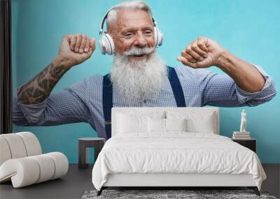 Old hipster man dancing to music playlist whit wireless headphone Wall mural