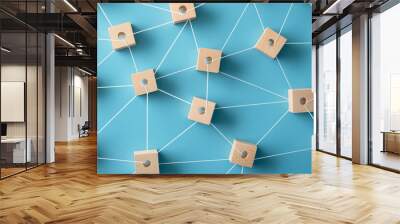 Abstract social network concept with wooden blocks connected by white strings on a blue background, top view.  Wall mural