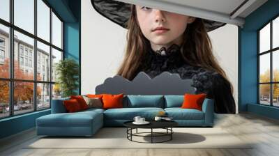 Little girl dressed as a witch holding black cloud sign Wall mural