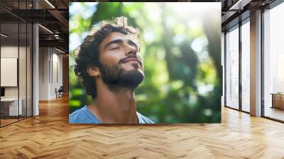 Portrait of a young man taking deep breath fresh air with copy space. Relaxation and well-being concept Wall mural