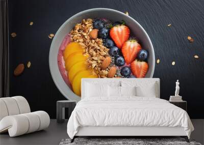 Smoothie bowl with fresh fruit and granola topping, on black background Wall mural