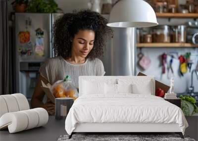 woman is opening her cardboard food delivery box in the kitchen Wall mural