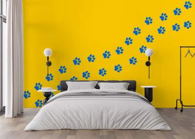 Paws of a cat, dog, puppy in blue color on a yellow background in a flat design. Diagonal animal footprints for veterinary clinic websites, cute pet posters.  Wall mural