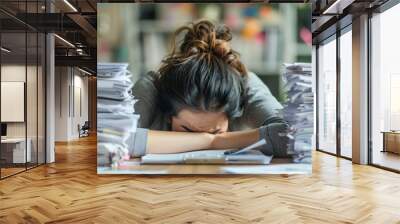 Exhausted office worker with head on desk, surrounded by piles of paperwork Wall mural