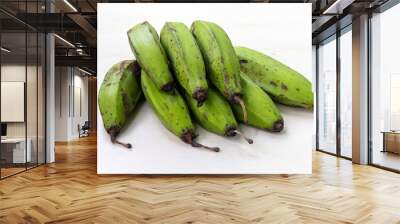 Bunch of green raw bananas on light white wooden background. Wall mural