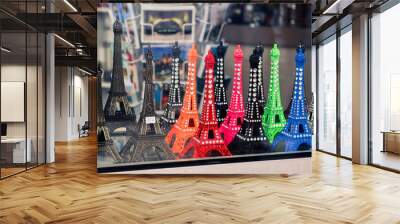 Miniature Eiffel Tower statues in vibrant colors for sale at a local souvenir shop in Paris Wall mural