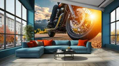 Close-up of a motorcycle's front wheel riding on the road in the mountains, with the focus on the bike and spinning wheels at sunset. Concept for heavy motorcycle travel Wall mural