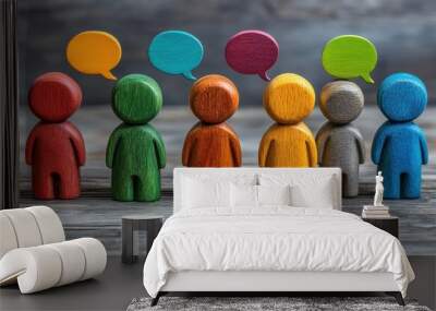 Wooden figures representing people standing in different directions with speech bubbles containing text in different colors, symbolizing online communication and interaction. Wall mural