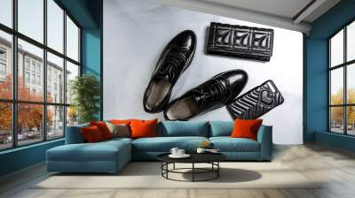 black perforated shoes oxfords, a purse and a phone case on a paper white background Wall mural