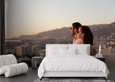 Young couple enjoying a city view from the roof terrace Wall mural