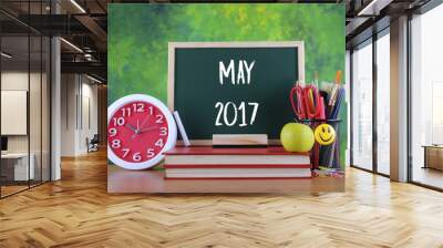 Back to school concept with alarm clock, books, a chalkboard and stationery with text MAY 2017 Wall mural