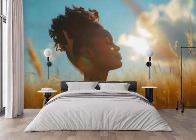 Backlit Portrait of calm happy smiling free african woman with closed eyes enjoys a beautiful moment life on the fields at sunset Wall mural