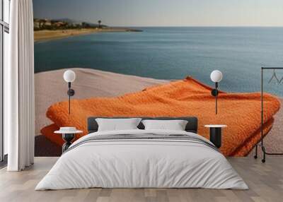 towels on the beach, orange towel set against the backdrop of a tranquil beach with ample empty space around for overlaying text Wall mural