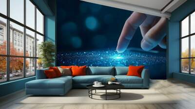 A close-up of a finger touching a glowing, digital interface with sparkling particles, representing technology and innovation. Wall mural